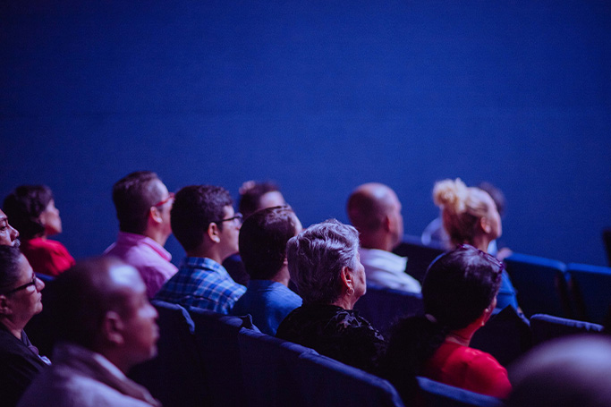 Personas en el cine viendo peliculas sobre cientificos