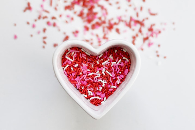 Molde en forma de corazón con sustancias químicas de colores blanco, rojo y rosa en su interior