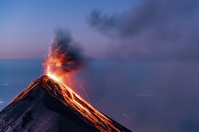 Erupcion de un volcan con expulsion de lava frenta al mar