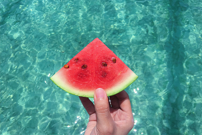Frutas de verano como la sandía sobre el agua de una piscina