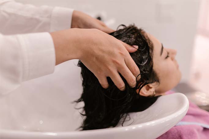 Mujer lavando su cabello con champu